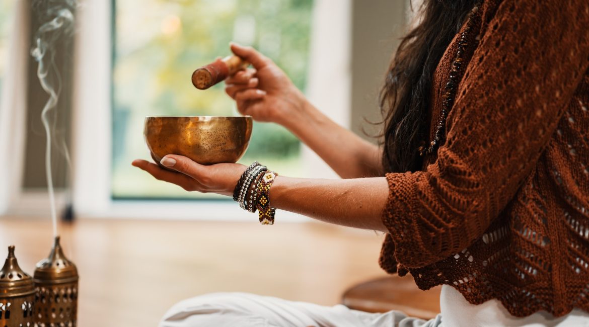 woman in brown knit sweater holding brown ceramic cup