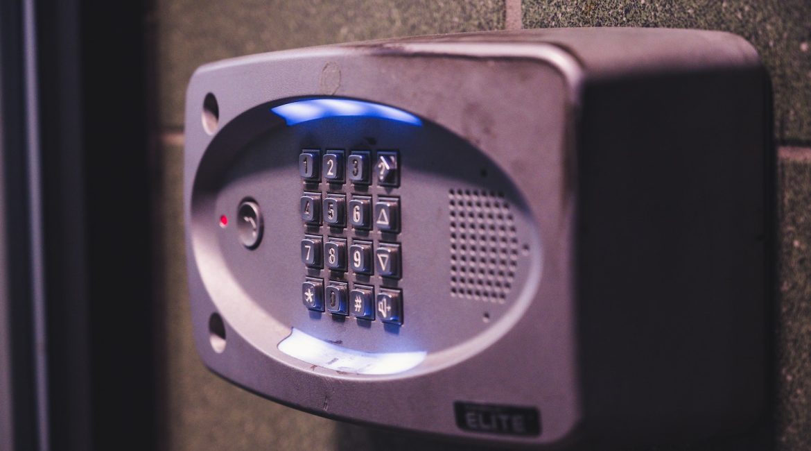 Close-up of a keypad access control system mounted on a wall, with illuminated buttons