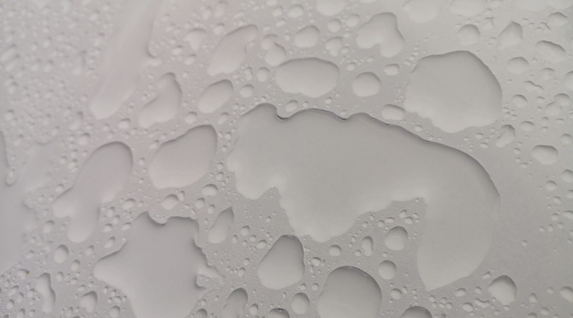Close-up of water droplets on a smooth surface, creating an abstract pattern