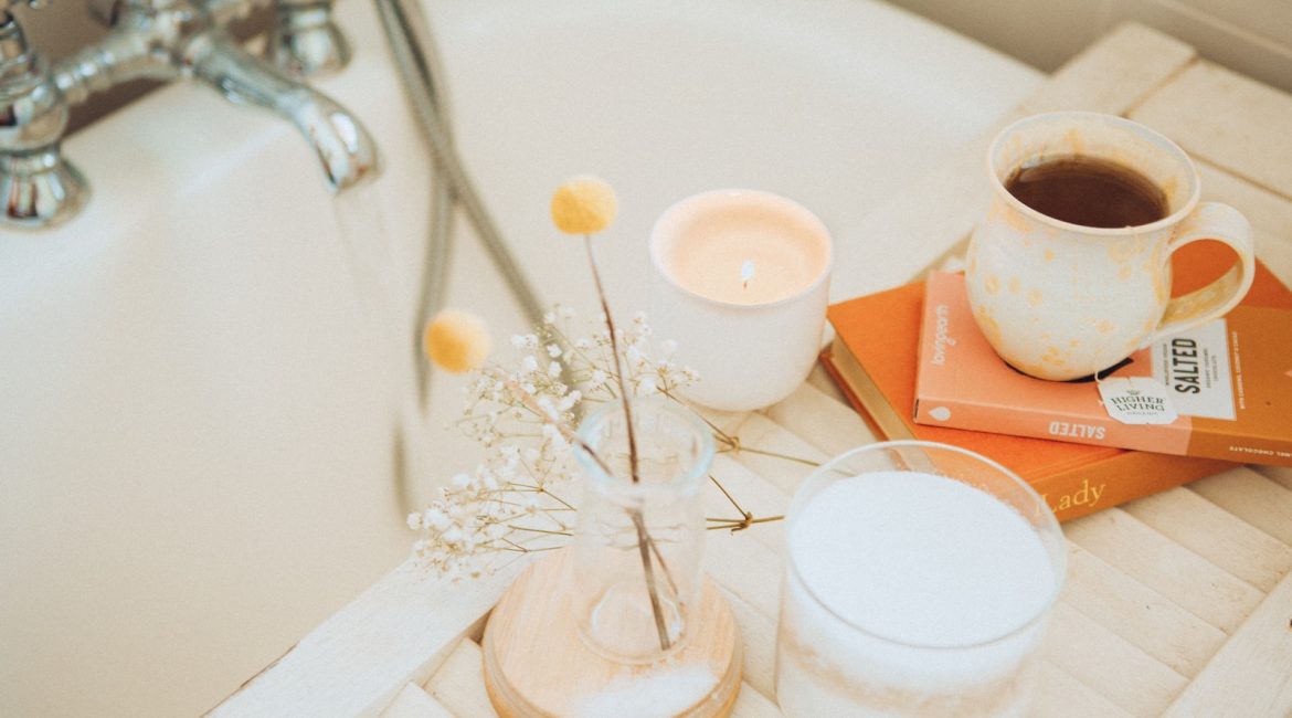 a cup of coffee and some books on a bathtub