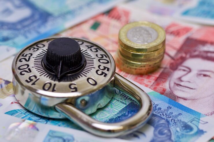 Combination lock and British currency symbolize security in finance.